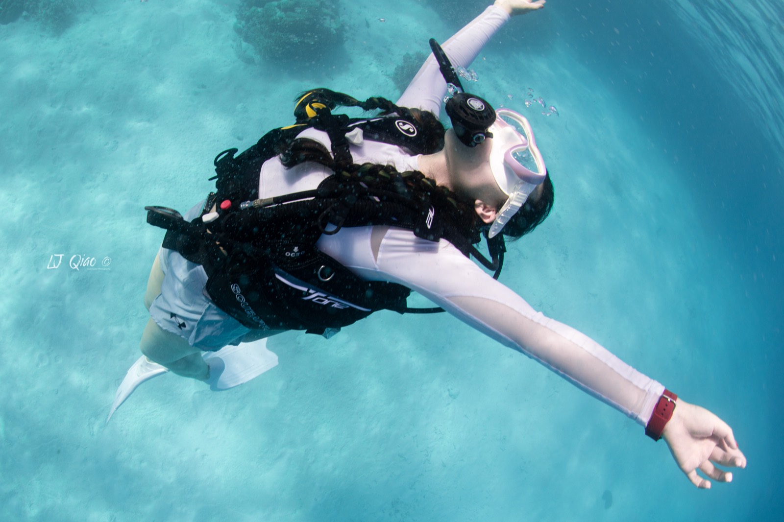 Diver posing with open arms in clear Palau water